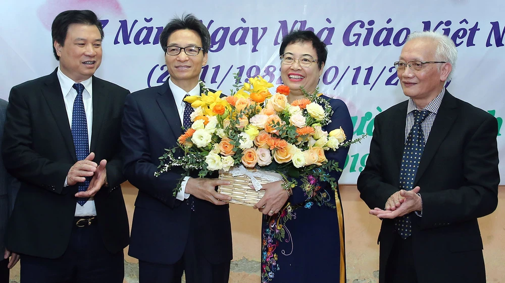 Phó Thủ tướng Vũ Đức Đam tặng hoa chúc mừng đội ngũ giáo viên trường THPT Đinh Tiên Hoàng nhân Ngày Nhà giáo Việt Nam. Ảnh: VGP
