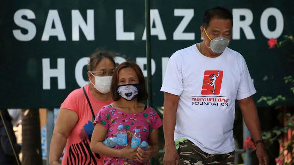 Người dân đeo khẩu trang đi ngang qua bệnh viện San Lazaro ở Manila, Philippines hôm 31-1-2020. Ảnh: The Philippines Star