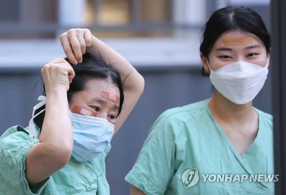 Nhân viên y tế sử dụng băng cá nhân để che vết thương trên mặt do đeo kính bảo hộ trong nhiều giờ trong khi điều trị cho bệnh nhân nhiễm Covid-19 tại Bệnh viện Dongsan ở Daegu vào ngày 4-3. Ảnh: Yonhap