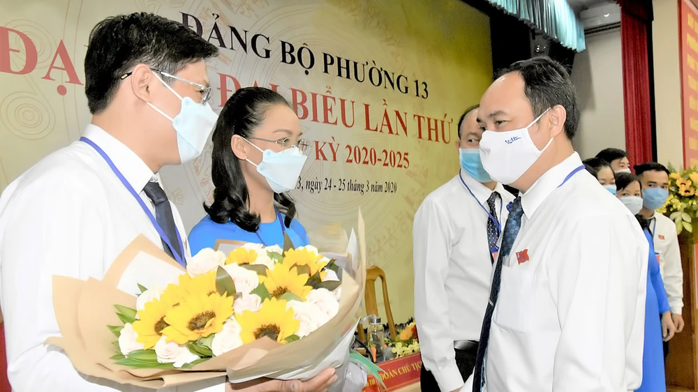 Bí thư Quận ủy quận Tân Bình Lê Hoàng Hà (bên phải) chúc mừng đồng chí Hoàng Văn Tài tái đắc cử chức Bí thư Đảng ủy phường 13, nhiệm kỳ 2020-2025