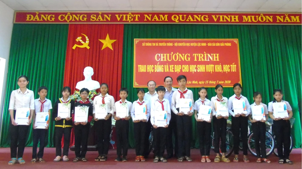 Các em học sinh nghèo Lộc Ninh nhận học bổng và quà tặng của chương trình