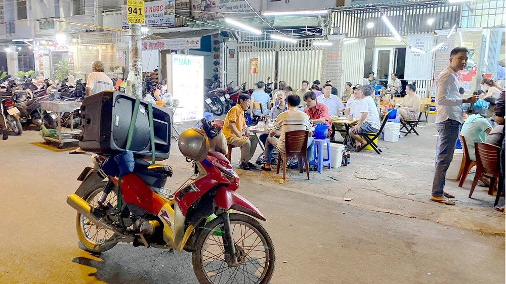 Người dân thường xuyên bị “tra tấn” bởi âm thanh từ loa di động trước các quán nhậu (ảnh chụp tối 9-3 trên đường Tạ Quang Bửu, quận 8, TPHCM). Ảnh: CAO THĂNG