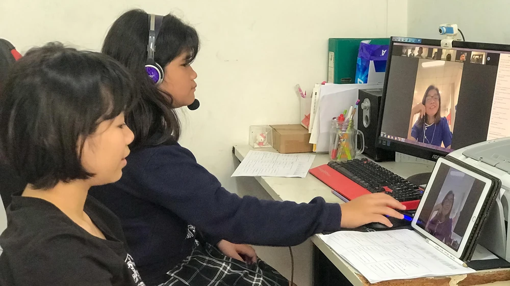 Hai chị em Hoàng Hà - Ái Linh, học sinh lớp 5 một trường tiểu học ở quận Tân Phú, TPHCM trong một giờ học trực tuyến tại nhà. Ảnh: HUỲNH NGA
