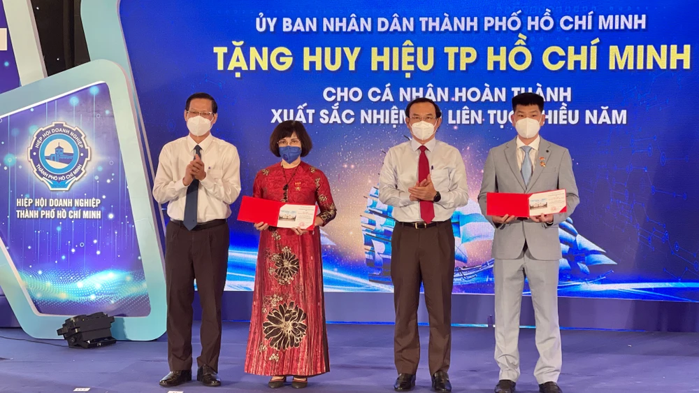 Bí thư Thành ủy TPHCM Nguyễn Văn Nên và Chủ tịch UBND TPHCM Phan Văn Mãi tặng Huy hiệu TPHCM cho các doanh nhân tiêu biểu. Ảnh: HOÀNG HÙNG