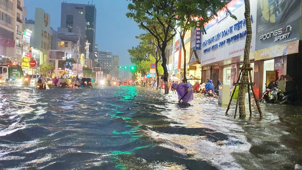 Người dân khơi thông miệng cống trong đêm mưa lũ 14-10 tại đường Nguyễn Văn Linh (quận Hải Châu, TP Đà Nẵng). Ảnh: XUÂN QUỲNH