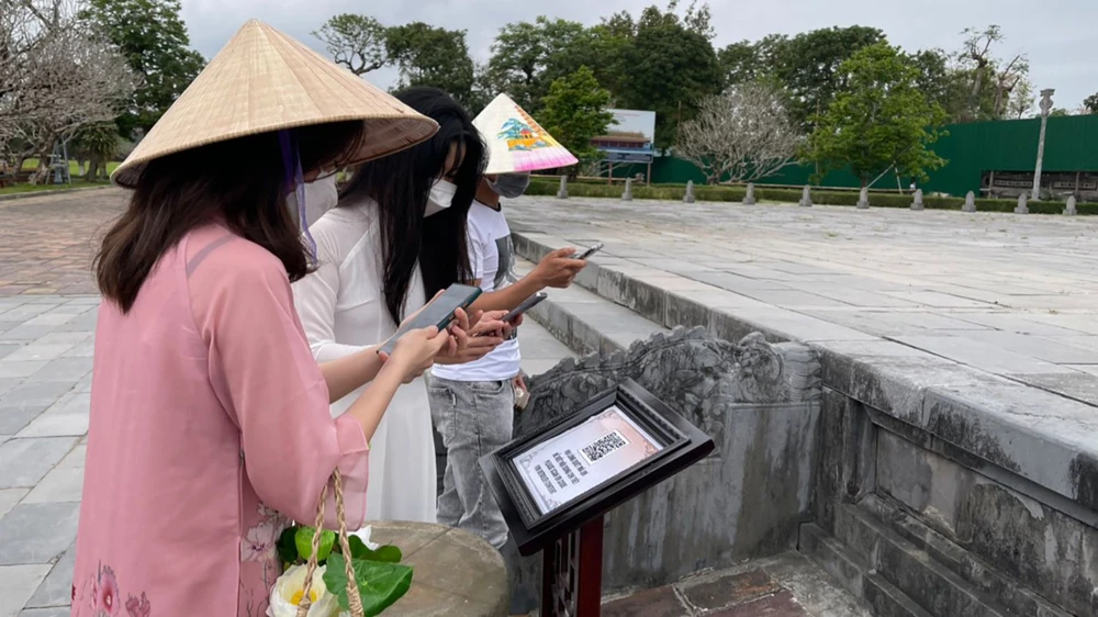 Du khách quét mã QR trên điện thoại thông minh để ngắm điện Thái Hòa qua tour du lịch thực tế ảo