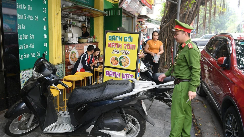 Lực lượng chức năng xử lý tình trạng tái lấn chiếm vỉa hè trên một số tuyến phố Hà Nội. Ảnh: VIẾT CHUNG