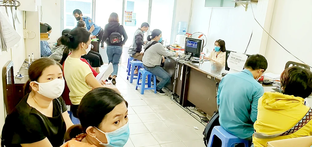 Người dân đang thực hiện các thủ tục bảo hiểm tại Bảo hiểm xã hội quận Gò Vấp. Ảnh: ĐOÀN HIỆP