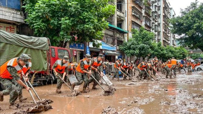 Lực lượng cảnh sát Trung Quốc dọn bùn sau mưa bão tại Trùng Khánh ngày 4-7-2023. Ảnh: THX