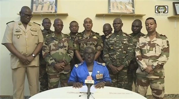 Đại tá Amadou Abdramane (ngồi), Người Phát ngôn của Hội đồng Quốc gia Bảo vệ Tổ quốc (CNSP) tại Niger, tuyên bố đảo chính trên truyền hình quốc gia ngày 26-77