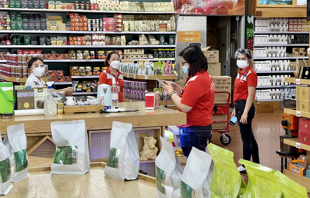 Nhân viên siêu thị Lotte Mart đang trưng bày sản phẩm nông sản Việt lên kệ bán hàng. Ảnh: HOÀNG HÙNG