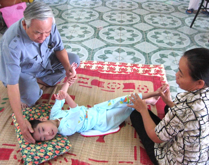 Ông Lê Văn Hoan thăm một cháu bé được phục hồi chức năng