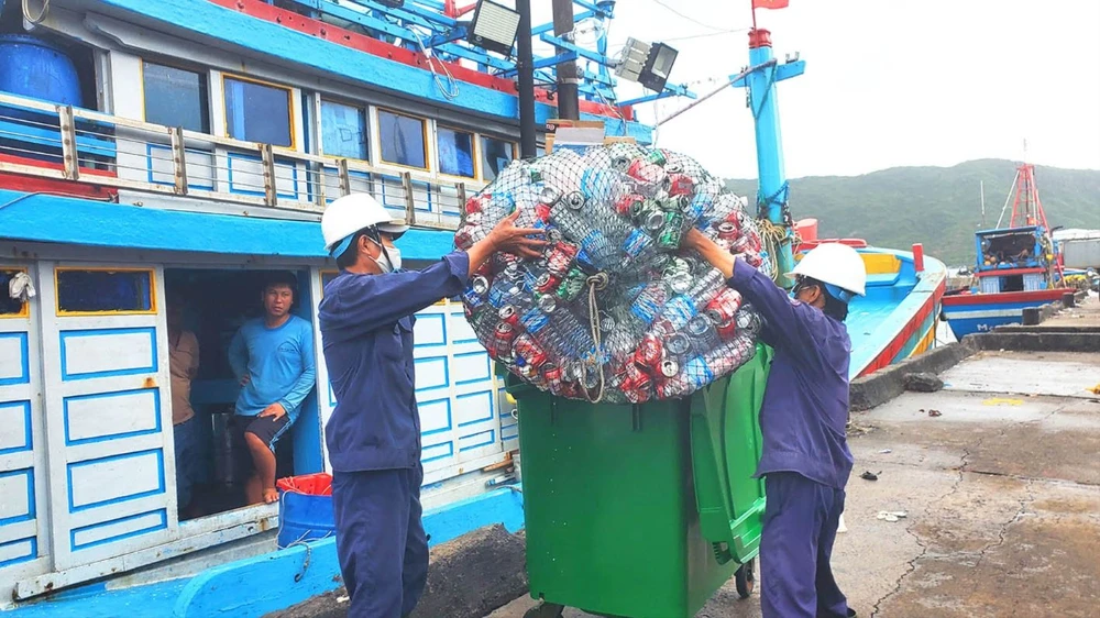 Các nhân viên môi trường cảng cá Quy Nhơn tiếp nhận rác thải nhựa từ 1 tàu đánh cá ngừ để đưa về khu phân loại, tái chế