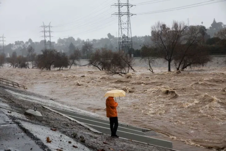 Một người dân chứng kiến lũ lụt nhấm chìm khu vực xung quanh thành phố Los Angeles, ảnh chụp vào ngày 5-2. Ảnh: REUTERS