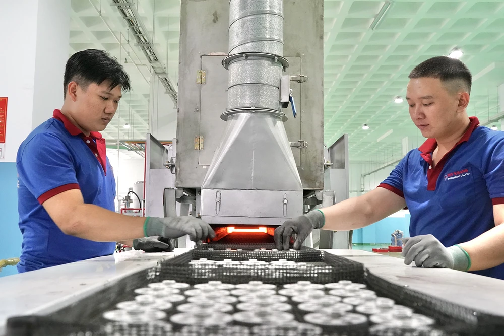 Sản phẩm từ ép bột kim loại của Công ty TNHH Cơ khí Duy Khanh đang được đưa vào dây chuyền gia nhiệt. Ảnh: HOÀNG HÙNG