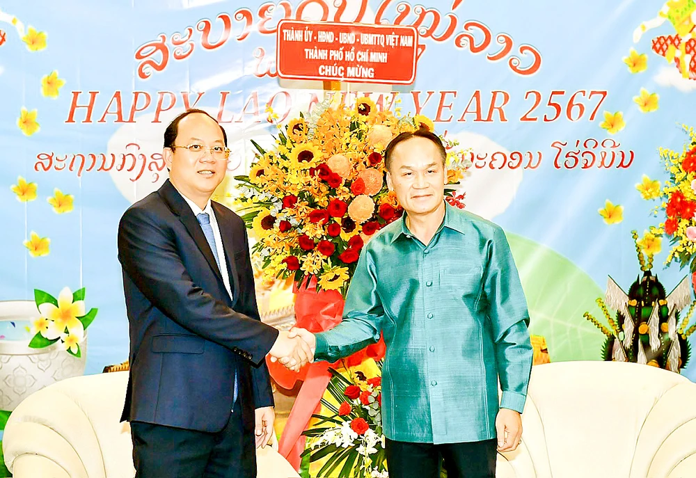 Phó Bí thư Thường trực Thành ủy TPHCM Nguyễn Hồ Hải tặng hoa chúc mừng Tổng Lãnh sự quán Lào tại TPHCM nhân dịp Tết cổ truyền của Lào. Ảnh: VIỆT DŨNG