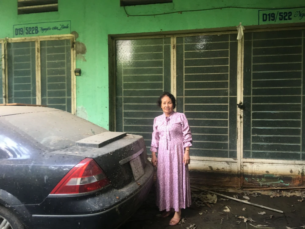 Bà Lưu Thị Thu trước ngôi nhà của mình đã bị ngâm nước lâu ngày, hư hỏng nặng