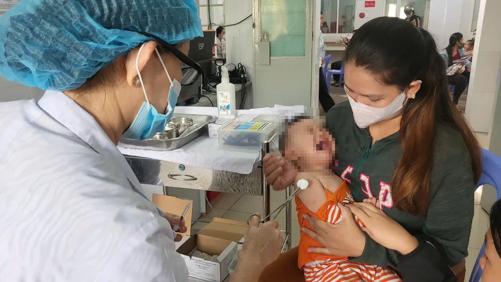 Nhân viên y tế tiêm vaccine cho trẻ