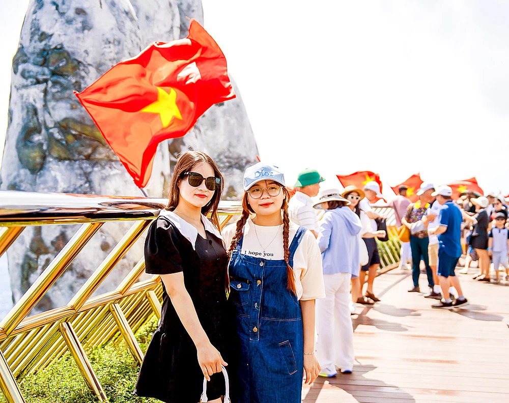 Du khách tham quan Khu du lịch Sun World Ba Na Hills (TP Đà Nẵng) được trang trí hàng trăm lá cờ Tổ quốc. Ảnh: XUÂN QUỲNH