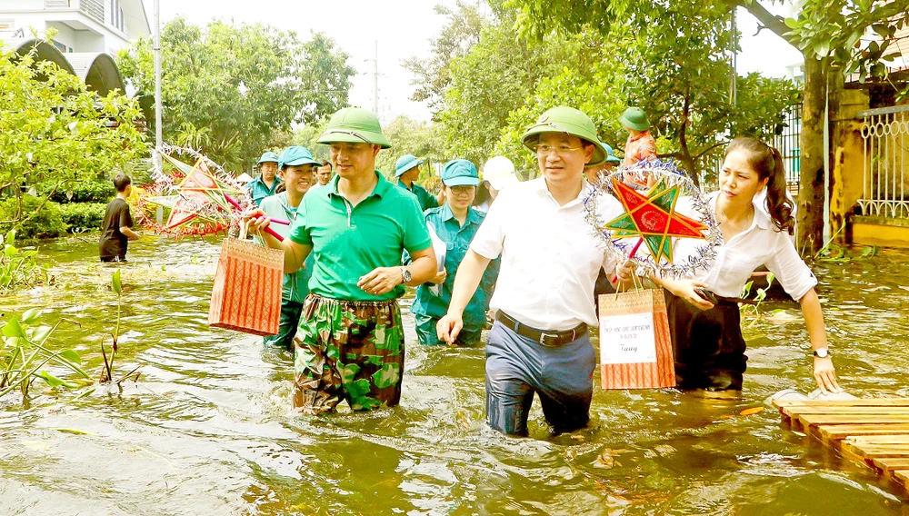 Các nghệ sĩ và các tổ chức, đoàn thể địa phương đến tận nhà những em nhỏ vùng bị ngập lụt ở Hà Nội để trao quà Trung thu. Ảnh: THU HÀ