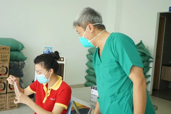 Thứ trưởng Bộ Y tế Nguyễn Trường Sơn hướng dẫn người dân tự lấy mẫu xét nghiệm.