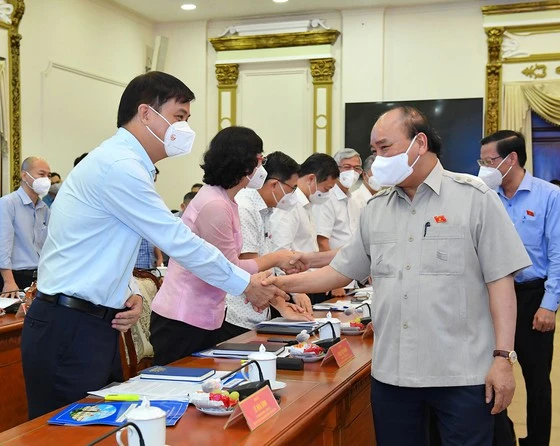 Chủ tịch nước Nguyễn Xuân Phúc trao đổi cùng lãnh đạo TPHCM. Ảnh: Việt Dũng. 