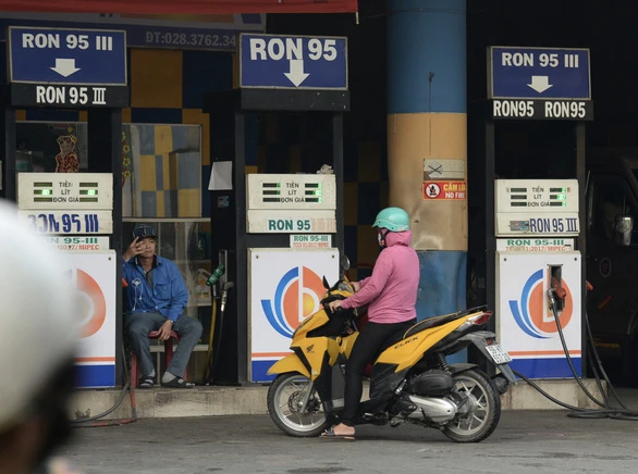Tại một trạm xăng ở quận Bình Tân, TP.HCM, nhân viên ngồi ra hiệu hết xăng khi khách đến mua (ảnh chụp chiều 21-2) - Ảnh: T.T.D.