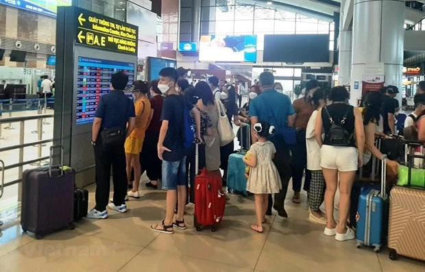 Hành khách theo dõi lịch bay của hãng hàng không tại sân bay Nội Bài. (Ảnh: Việt Hùng/Vietnam+)