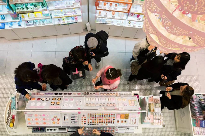 Một nhân viên bán hàng đang giúp khách chọn mỹ phẩm tại một cửa hàng thuộc tập đoàn Amorepacific tại khu mua sắm Myeongdong, Seoul. Ảnh: Bloomberg.
