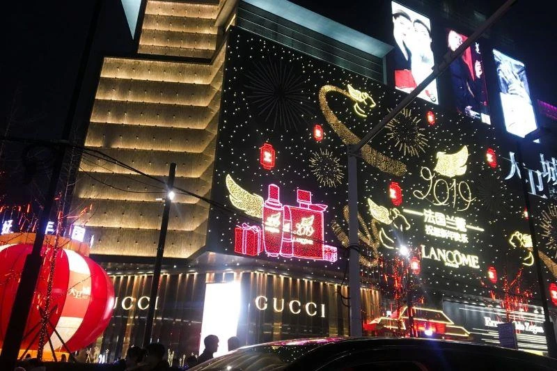 Luxury brand names illuminate the facade of a shopping mall in Zhengzhou, Henan province, China. The nation’s wealthy have a particular impact on international purveyors of luxury automobiles, fashion and food brands. PHOTO: YAWEN CHEN/REUTERS