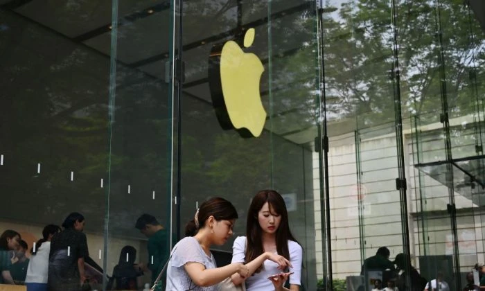 Women use their smartphones in front of an Apple store in Tokyo's Omotesando district on June 4, 2019. (CHARLY TRIBALLEAU/AFP/Getty Images)