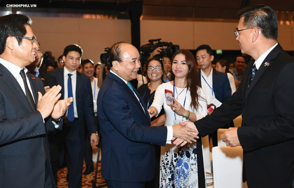 Prime Minister Nguyen Xuan Phuc talks with delegates attending the Conference in 2018.