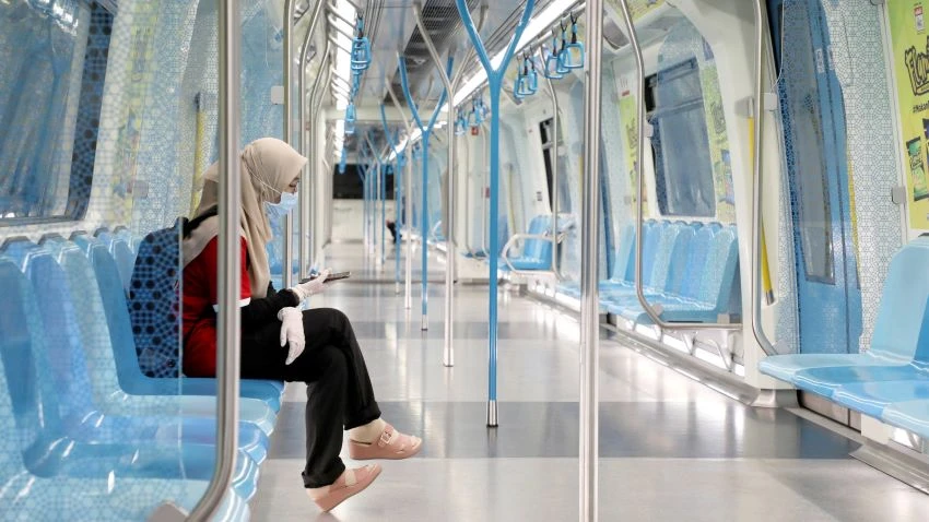 A woman wearing protective mask and gloves seen on a Mass Rapid Transit train during a movement control order in Kuala Lumpur on Sunday. © Reuters