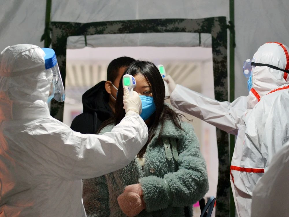 Một nhân viên chính phủ kiểm tra nhiệt độ cơ thể của khách du lịch tại một nhà ga ở Fuyang, Trung Quốc vào ngày 29 tháng 1.