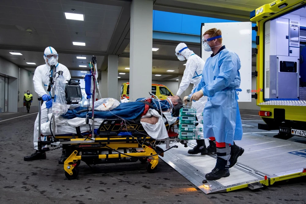 Nhân viên y tế chuyển bệnh nhân nhiễm COVID-19 lên xe cứu thương tới bệnh viện ở Ulm, tây nam nước Đức, ngày 29/3. Ảnh: AFP/TTXVN