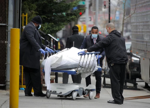 Các nhân viên vận chuyển một thi thể bên ngoài bệnh viện ở Brooklyn. (Ảnh: Reuters)