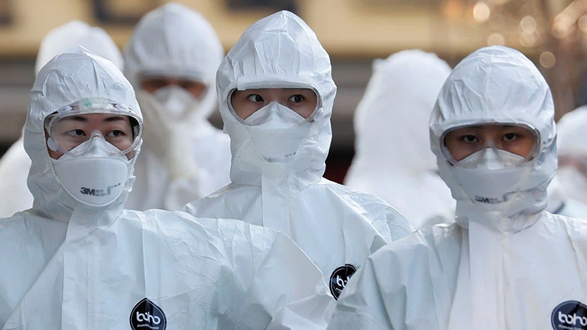 Medical workers in protective gear walk into a hospital facility to treat coronavirus patients in Daegu, South Korea, last month. © Reuters