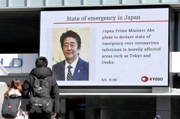 Người dân Nhật Bản theo dõi tin tức về việc Thủ tướng Shinzo Abe dự định sẽ ban bố tình trạng khẩn cấp do dịch COVID-19 ngày 6/4/2020. (Nguồn: Kyodo/TTXVN)