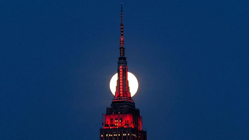 A supermoon rises behind the Empire State Building, glowing red in solidarity with coronavirus victims. © Reuters