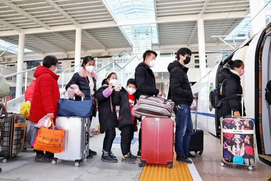  Các công nhân trở lại công việc của họ lên chuyến tàu đặc biệt G9383 từ Phụ Dương đến Ninh Ba, Chiết Giang, cùng với gia đình của họ tại ga tàu Phụ Dương, tỉnh An Huy phía đông Trung Quốc, 18-02-2020. (Ảnh Zhou Wei / Tân Hoa xã)