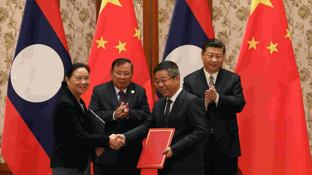 Ảnh minh họa - Chủ tịch lào Bounnhang Vorachith (phía sau bên trái) và Chủ tịch Trung Quốc Tập Cận Bình trong một ký kết hợp tác (Nguồn: cgtn)