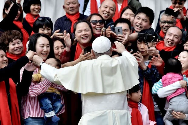 Giáo hoàng Francis chào đón các tín hữu từ Trung Quốc khi ông đến dự buổi tiếp kiến ​​chung hàng tuần của mình tại Quảng trường Thánh Peter ở Vatican vào 18-04 Ảnh: TIZIANA FABI/AGENCE FRANCE-PRESSE/GETTY IMAGES