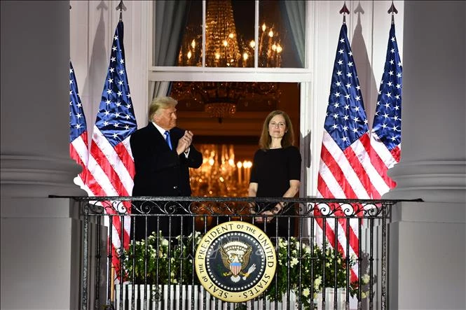 Tổng thống Mỹ Donald Trump (trái) chúc mừng bà Amy Coney Barrett (phải) sau lễ tuyên thệ nhậm chức Thẩm phán Tòa án Tối cao tại Washington, DC ngày 26/10/2020. Ảnh: AFP/TTXVN