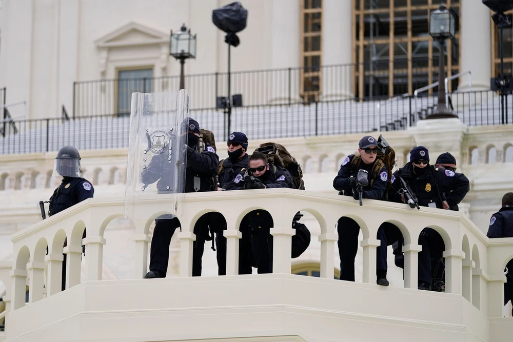 Cảnh sát theo dõi những người biểu tình cố gắng vượt qua hàng rào cảnh sát ngày 6-1 tại Điện Capitol ở Washington. Ảnh: Julio Cortez, AP