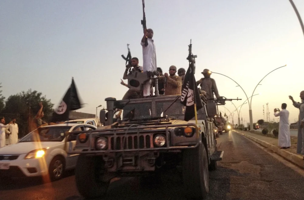  Các chiến binh IS diễu hành trên một chiếc xe bọc thép do lực lượng an ninh Iraq điều động vào năm 2014. Ảnh: AP