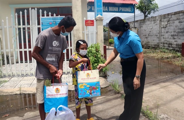 Representative of the Kiên Giang Labour Federation give food to poor residents in Bình An Commune, Châu Thành District. — VNA/VNS Photo Lê Huy Hải