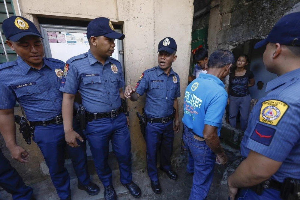 Cảnh sát Philippines và một sĩ quan cộng đồng địa phương trong chiến dịch chống ma túy bất hợp pháp ở thành phố Quezon, phía đông Manila, năm 2018. Ảnh: EPA-EFE