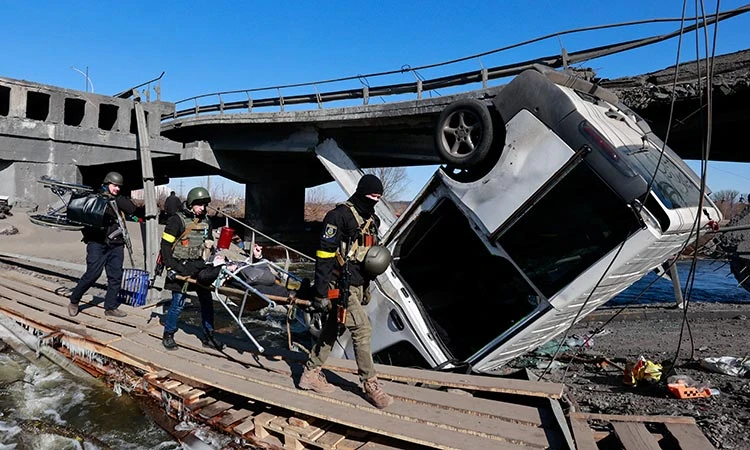 Mọi người băng qua sông Irpin bên cạnh một cây cầu bị phá hủy, trong bối cảnh Nga tấn công Ukraine, ngoại ô Kyiv. @Reuters
