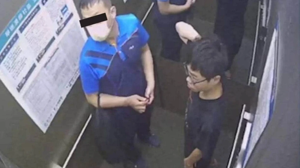 Hsia (trái) và 'Tiểu' Lai bên trong thang máy của tòa nhà chung cư vào buổi sáng Lai được tìm thấy bị chết bên ngoài tòa nhà.