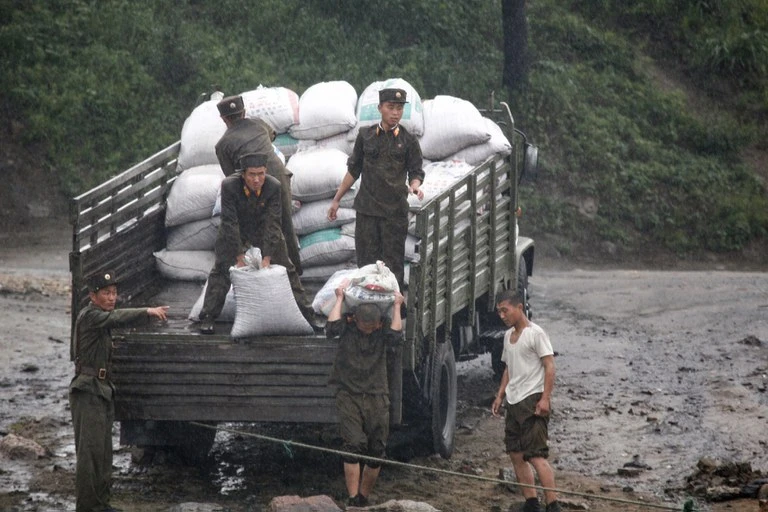 Binh lính Triều Tiên dỡ thực phẩm trên bờ sông Áp Lục gần thị trấn Sinuiju của Triều Tiên, ngày 5/6/2009. Ảnh: Jacky Chen/Reuters